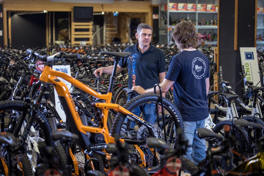 Zwei Menschen unterhalten sich in einem Fahrradladen