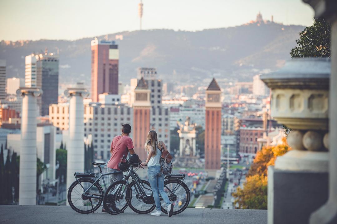Zwei Personen fahren mit einem E-Bike in der Stadt